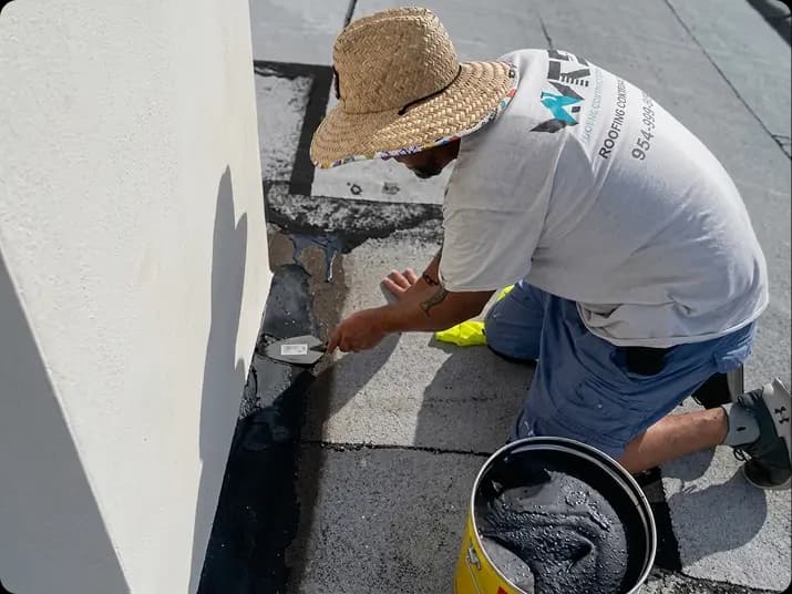 Weather Recovery Solutions technician sealing a flat roof leak during an emergency response call in South Florida.
