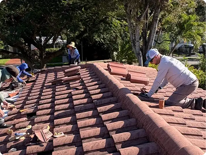 Weather Recovery Solutions roofers replacing damaged barrel tiles during a residential roof repair in South Florida.